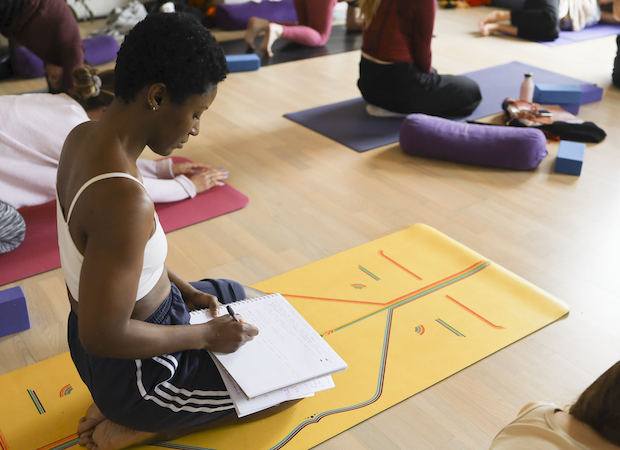 Trainee yoga teacher taking notes on 300-hour yoga teacher training