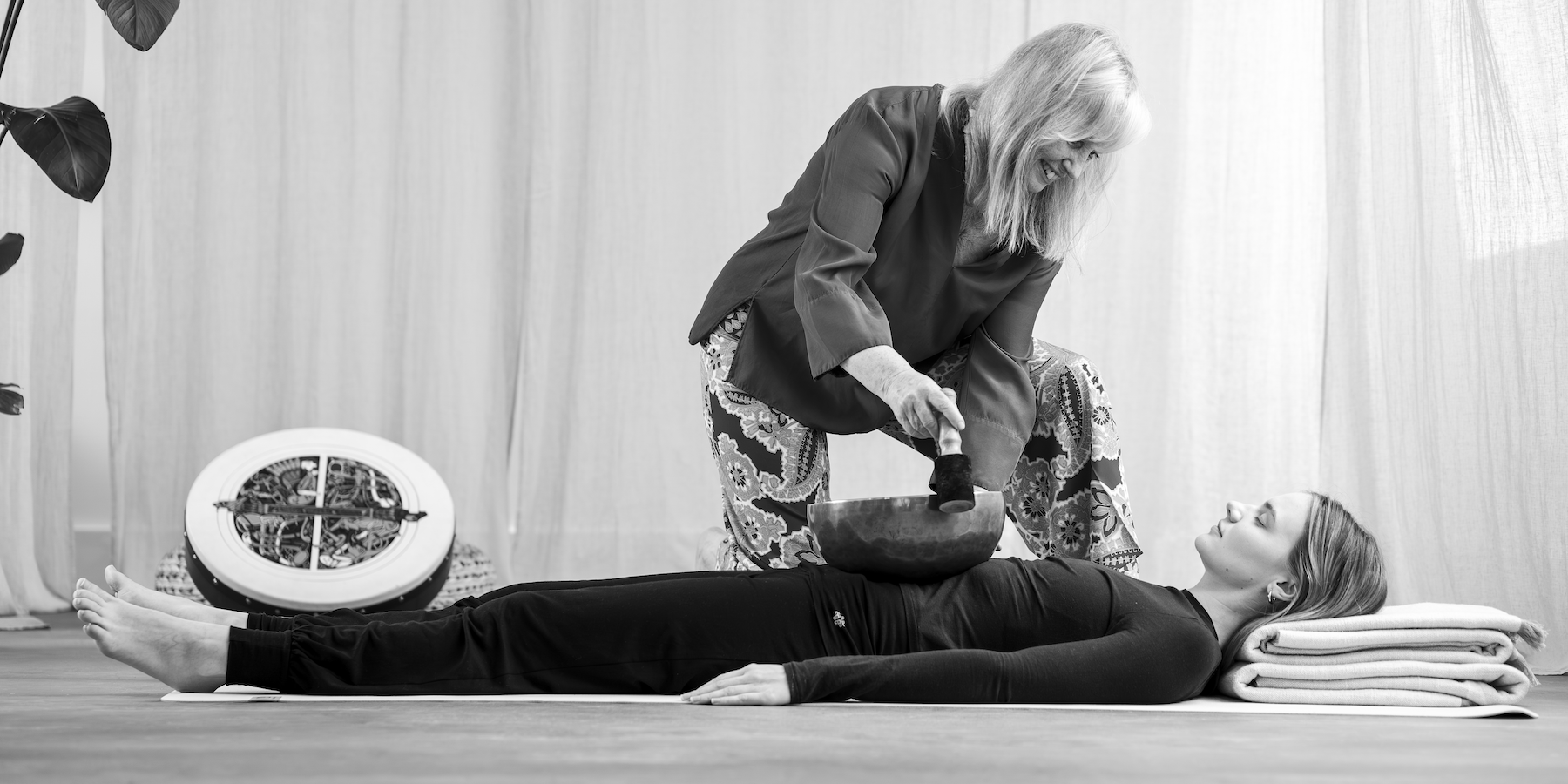 Anne Malone using sound bowl on her student to demontrate