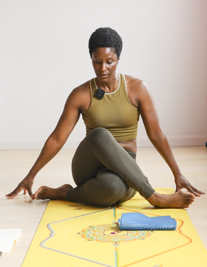 Trainee teaching a group on a yoga teacher training course